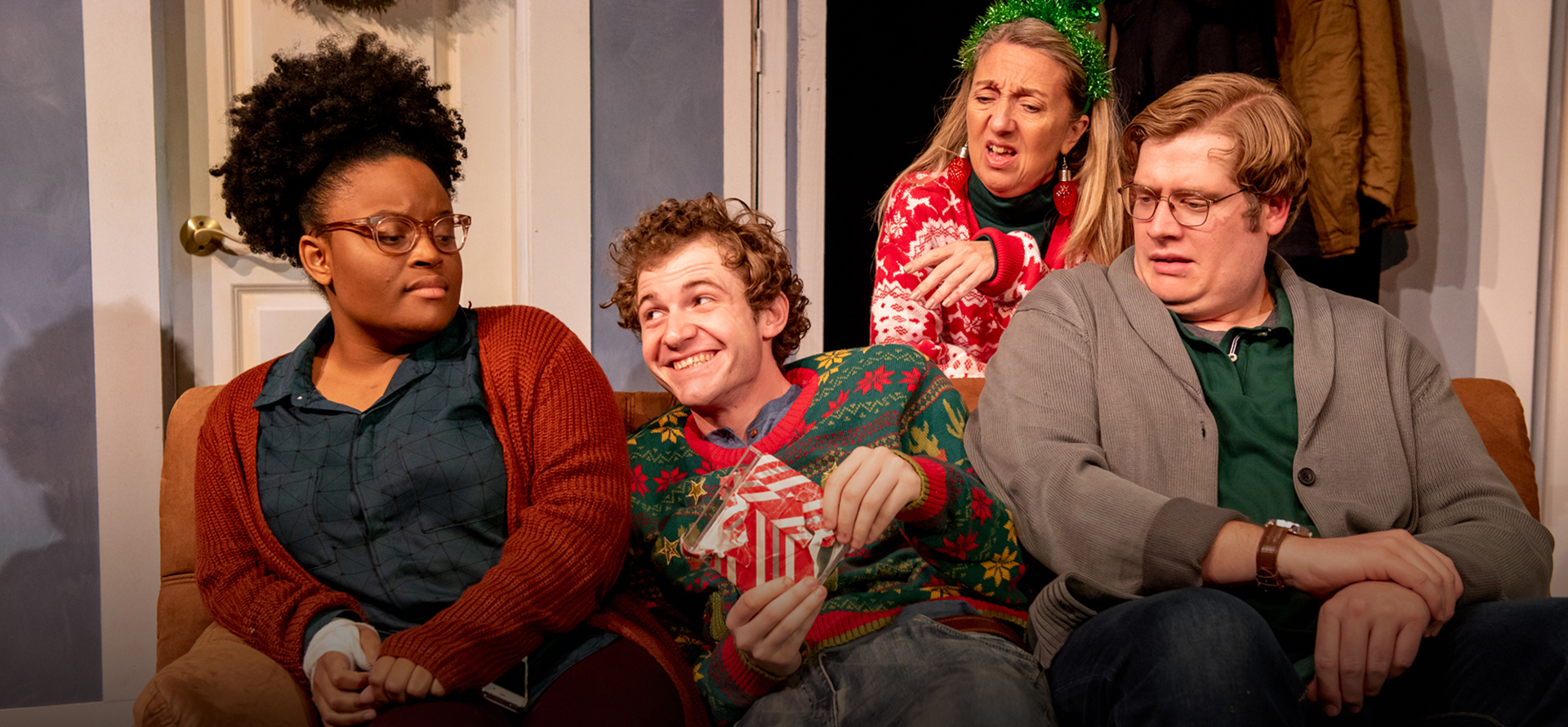 Four people on stage in play; one woman tending to plants